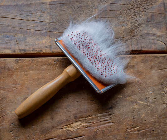 Kefa plná mačacích chlpov položená na drevenom podklade